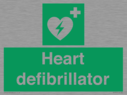 green-background-with-white-text-and-heart-defibrillator-symbol--white-cross-and~